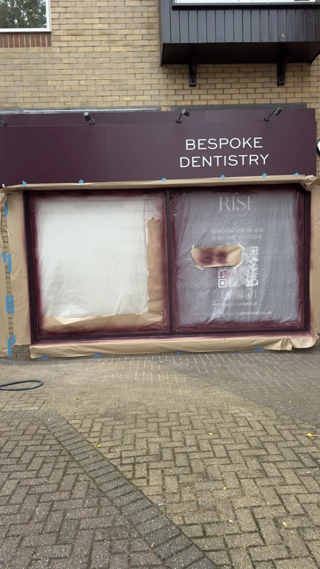Window frames sprayed burgundy with masking still covering the glazing