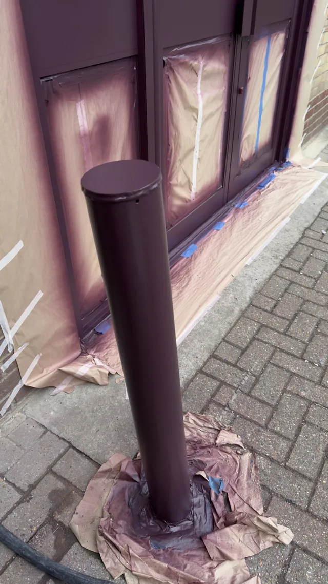 Rear bollard and door surfaces in burgundy with surrounding masking visible
