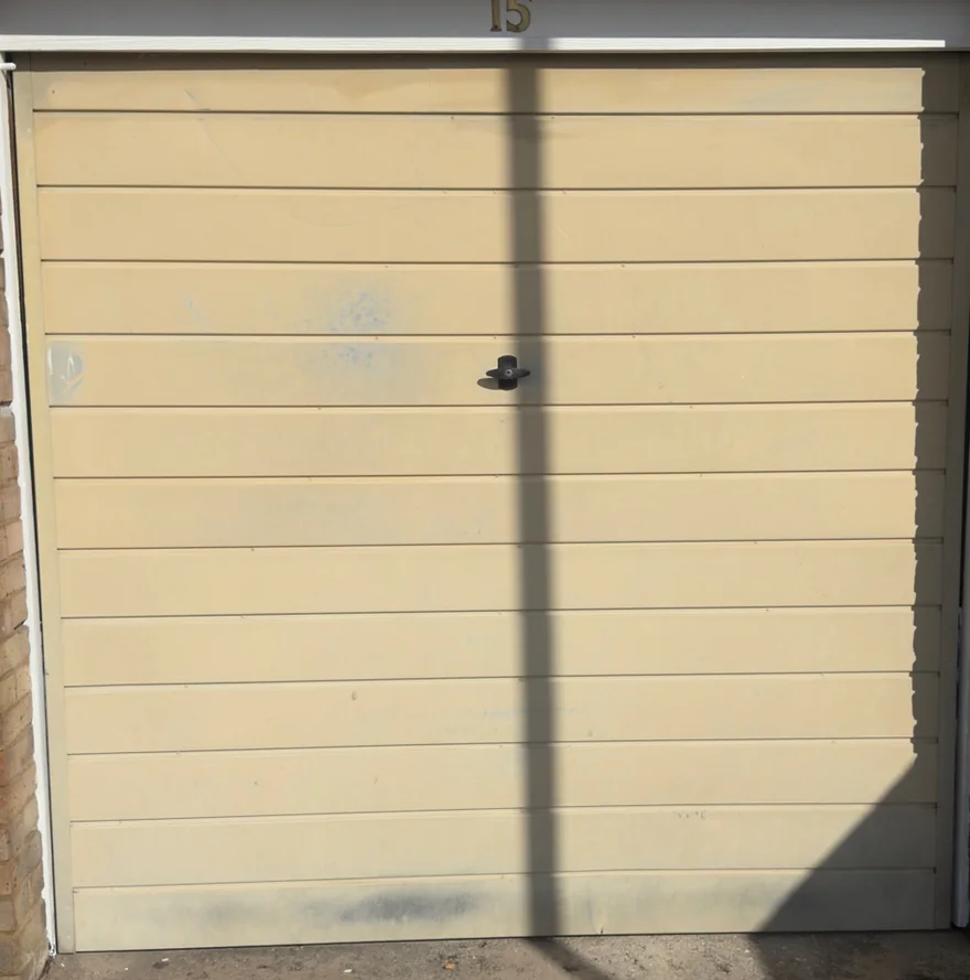 Bletchley garage door before respray, faded magnolia with staining and grime
