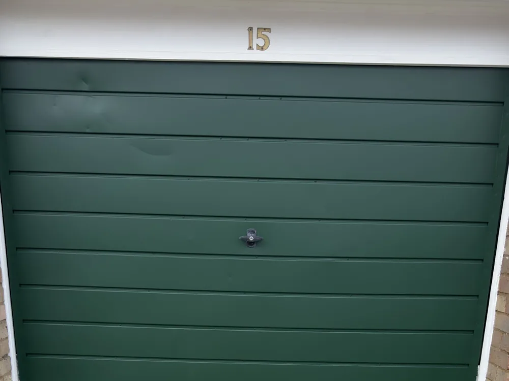 A resprayed garage door finished by ProFinish in RAL 6005 Moss Green satin, part of a full frontage refresh